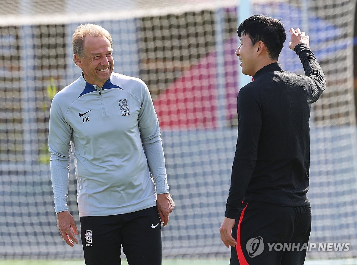 South Korea head coach Jurgen Klinsmann (L) and captain Son Heung-min chat during a training session for the Asian Football Confederation Asian Cup at Al Egla Training Site in Doha on Jan. 17, 2024. (Yonhap)