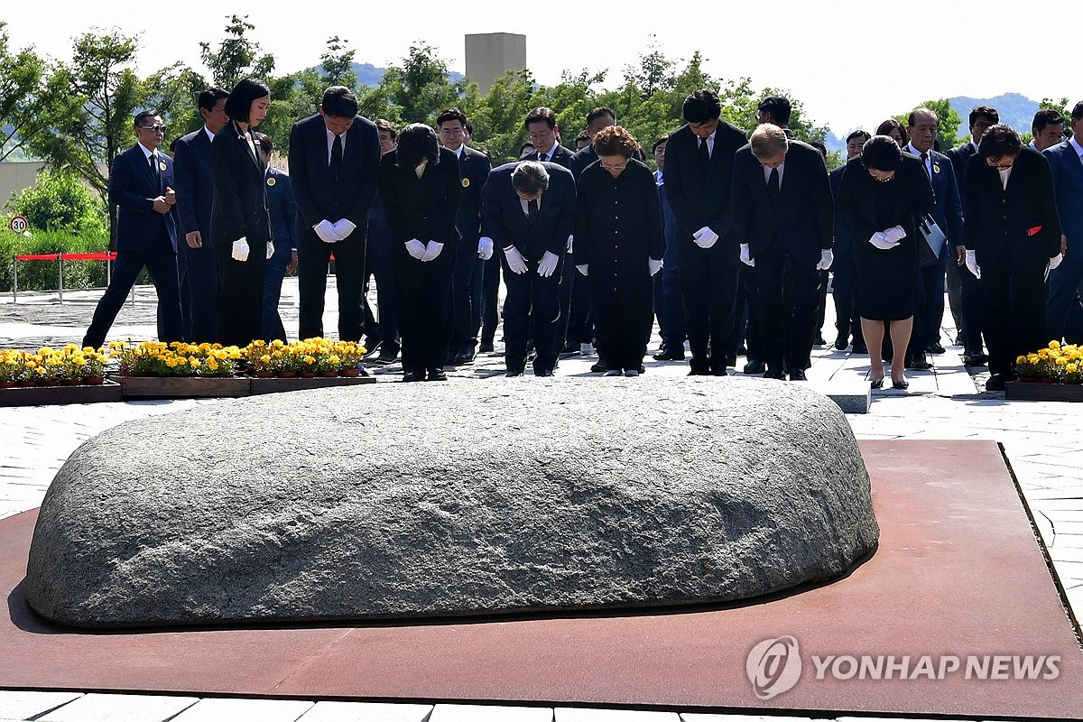 Los participantes, incluido el ex presidente Moon Jae-in (tercero desde la derecha), presentan sus respetos durante un acto conmemorativo que conmemora el 15º aniversario de la muerte del presidente Roh Moo-hyun frente a su tumba en Gimhae, a 303 kilómetros al sureste de Seúl, el 23 de mayo. 2024. (Foto de la piscina) (Yonhap)
