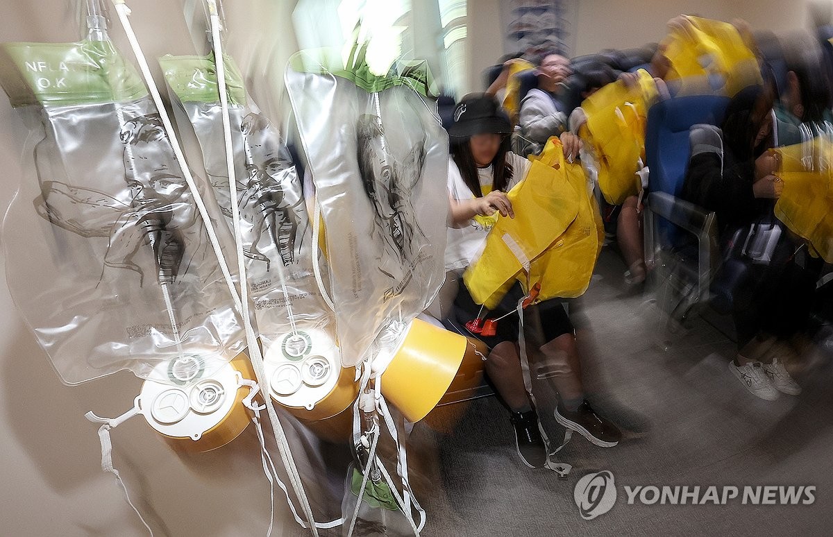 Esta foto de archivo, tomada el 29 de mayo de 2024, muestra a estudiantes aprendiendo cómo responder en caso de turbulencias aéreas en Daegu. (Yonhap)