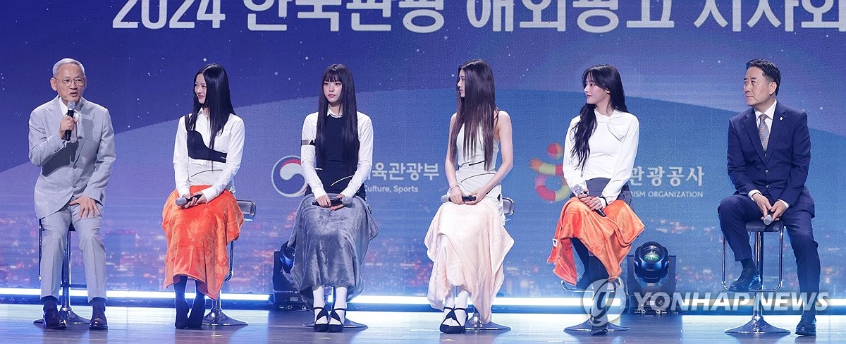 El grupo femenino de K-pop NewJeans escucha el discurso del ministerio de Cultura, Deportes y Turismo surcoreano, Yu In-chon (primero por la izda.), después de ser nombrado embajador honorario para el turismo surcoreano para 2024, el 11 de julio de 2024, en un hotel de Seúl.