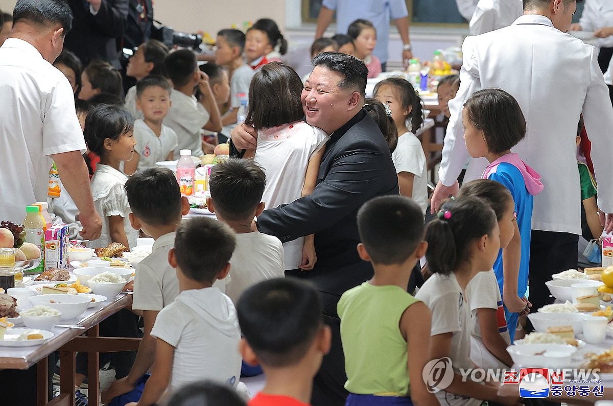 Esta fotografía, publicada por la Agencia Central de Noticias de Corea del Norte, el 16 de agosto de 2024, muestra al líder norcoreano Kim Jong-un (centro) abrazando a un niño que llegó a Pyongyang el día anterior debido a los daños causados ​​por las últimas inundaciones en las zonas fronterizas del norte del país. (Para uso exclusivo en la República de Corea. No se permite su distribución) (Yonhap)