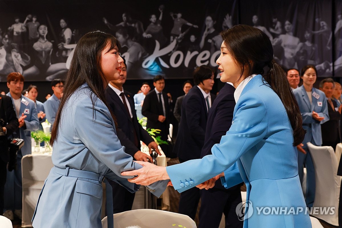 La primera dama Kim Keon Hee (derecha) saluda al campeón olímpico de tiro con arco de París, Lim Si-hyeon, durante una cena organizada por la oficina presidencial para los atletas olímpicos de Corea del Sur en un hotel de Seúl el 22 de agosto de 2024, en esta foto proporcionada por la oficina. (FOTO NO A LA VENTA) (Yonhap)