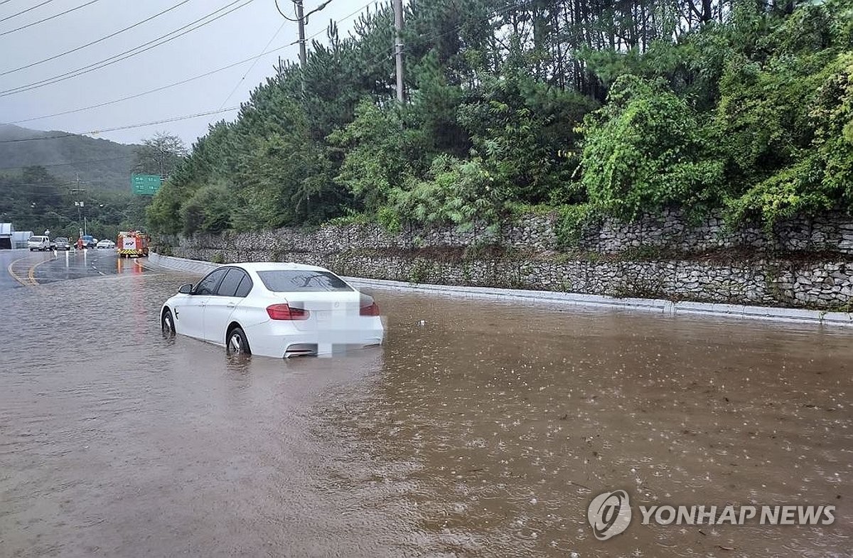 En esta foto proporcionada por la autoridad provincial de extinción de incendios, un automóvil se encuentra varado en una carretera inundada en el condado de Jangsu, en la provincia de Jeolla del Norte, después de que fuertes lluvias azotaran la región el 21 de septiembre de 2024. (FOTO NO A LA VENTA) (Yonhap)