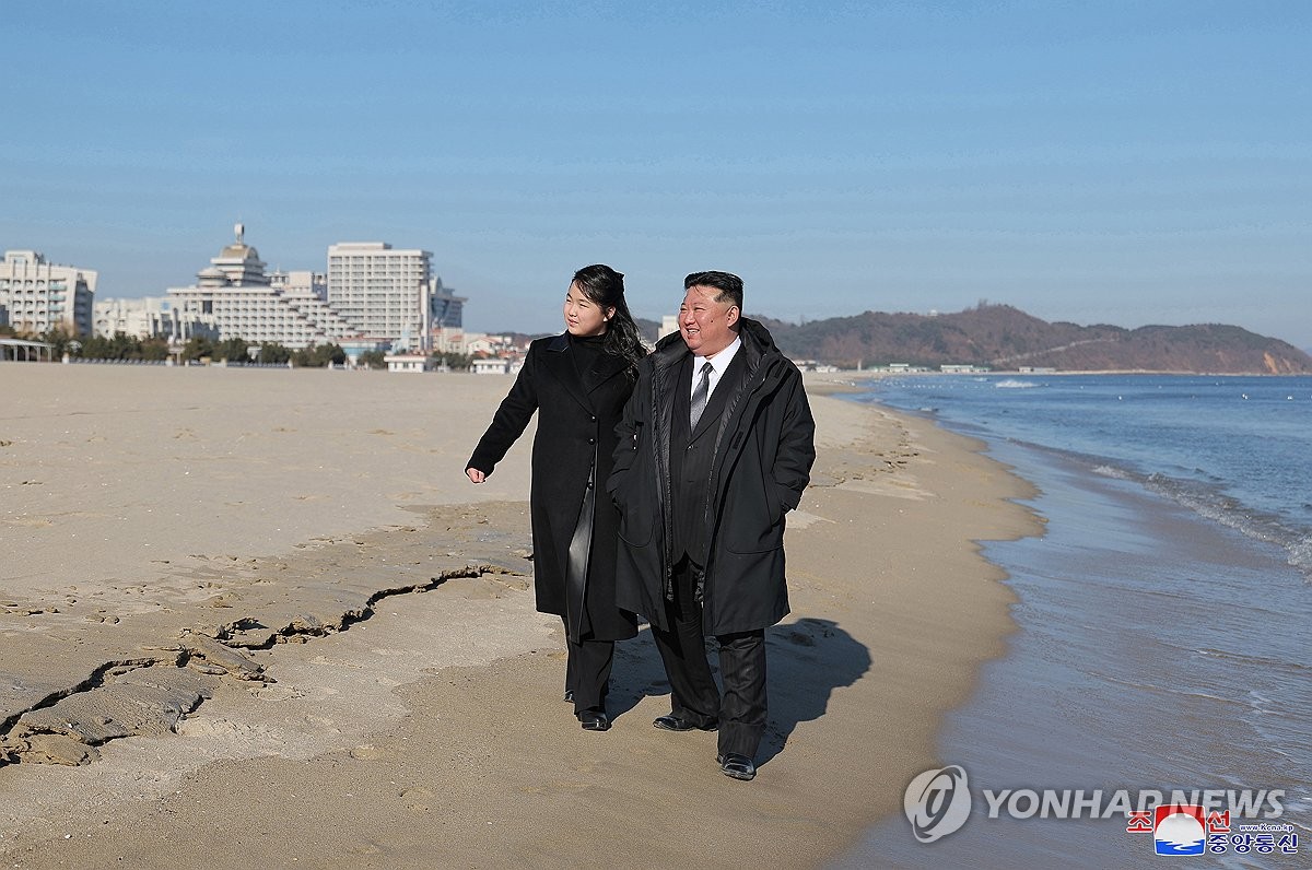 El líder norcoreano Kim Jong-un (derecha) y su hija caminan por una playa en la zona turística costera de Kalma, en la ciudad de Wonsan, en la costa este del país, en esta fotografía publicada por la Agencia Central de Noticias de Corea el 31 de diciembre de 2024. ( Para uso exclusivo en la República de Corea, sin redistribución) (Yonhap).