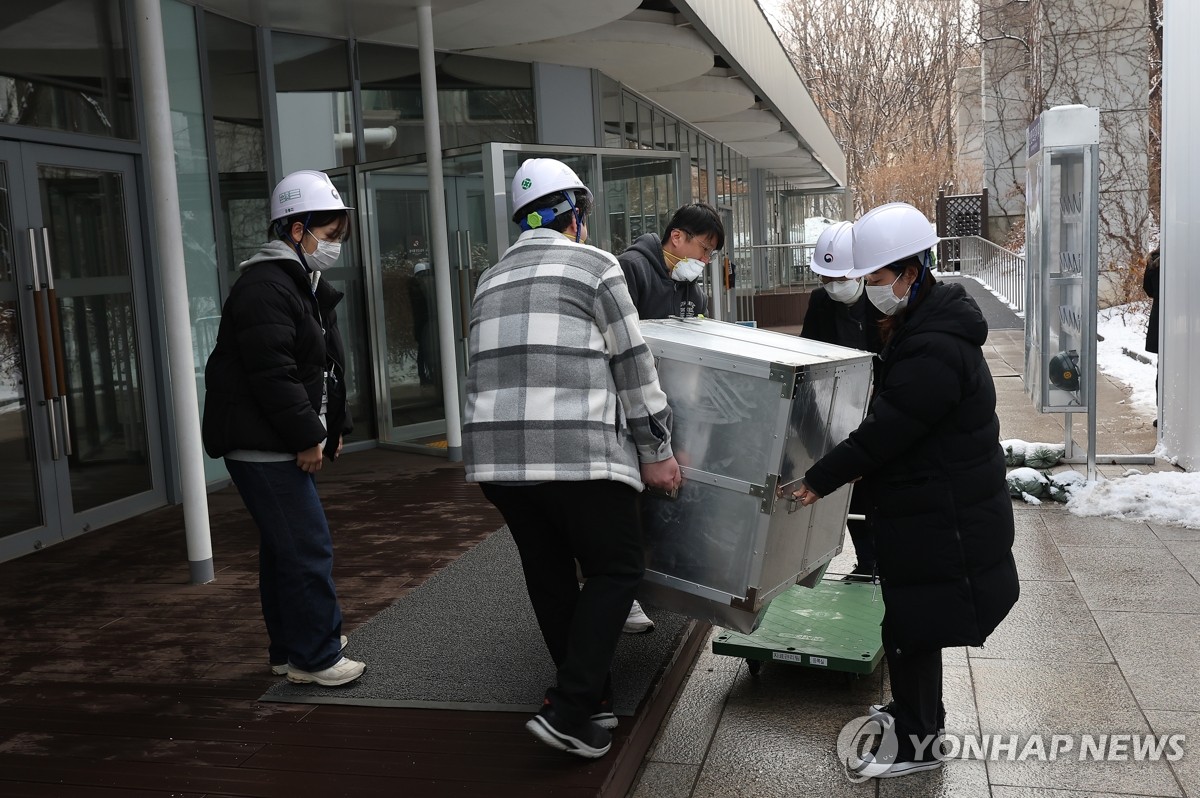 Funcionarios del Museo Nacional de Hangeul en el centro de Seúl mueven artefactos el 1 de febrero de 2025, después de que estalló un incendio en el tercer y cuarto piso del edificio. (Yonhap) 